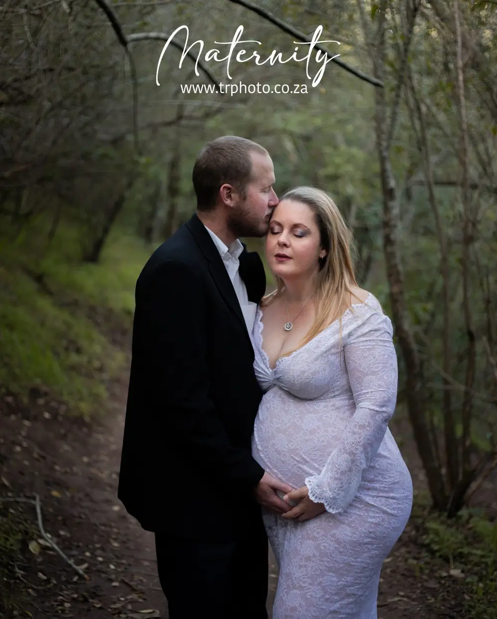 An expecting couple in a forest