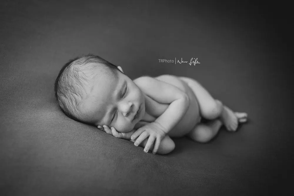 A sleeping newborn in black and white